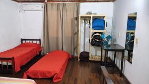 a room with two beds and a desk and a table at Departamento cercano al centro in Oberá