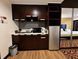 a kitchen with a refrigerator and a bed in a room at Cozy Studio at SCSP Suites in Kota Kinabalu