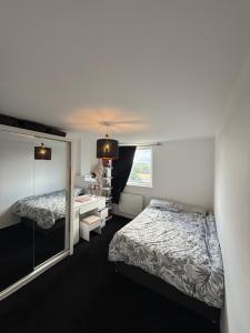 a bedroom with two beds and a desk and a window at Modern in Orpington