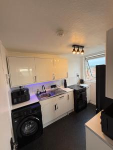 a kitchen with a washing machine and a sink at Modern in Orpington