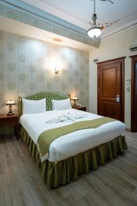 a bedroom with a large bed with a green headboard at Basileus Hotel in Istanbul