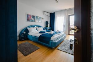 a bedroom with a blue bed and a window at Casa Ienciu in Sibiu