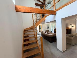 a wooden staircase in a living room with a couch at La Marcillande in Saint-Cyprien +21 photos