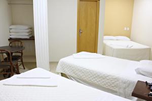 Postel nebo postele na pokoji v ubytování Dois Vizinhos Palace Hotel