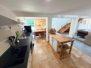 a kitchen and living room with a counter and a table at La Marcillande in Saint-Cyprien