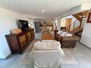 a living room with two couches and a television at La Marcillande in Saint-Cyprien
