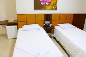 Postel nebo postele na pokoji v ubytování Dois Vizinhos Palace Hotel