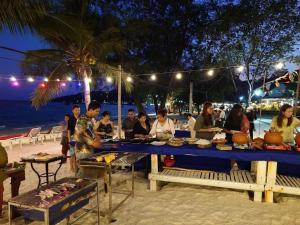 a group of people sitting at a table on the beach at Europe Enchanted Resort in Kaôh Rŭng (3)