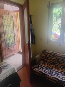 a bedroom with a bed and a door with a window at Ljiljana Apartman 1 in Rakari +1 photo