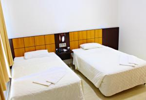Postel nebo postele na pokoji v ubytování Dois Vizinhos Palace Hotel