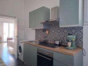 a kitchen with white cabinets and a stove top oven at Borghetto sant'irene in Erchie +3 photos