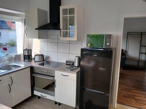 a kitchen with a stainless steel refrigerator and a sink at Ferien-Appartement Schröer in Nordwalde