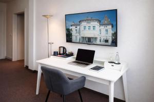 a white desk with a laptop computer on it at Hotel Adler & Eventlocation GmbH in Itzehoe