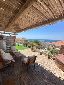 a patio with chairs and a wooden pergola at The Jaffa Roof in Tel Aviv