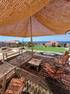 a patio with a table and chairs under a large umbrella at The Jaffa Roof in Tel Aviv