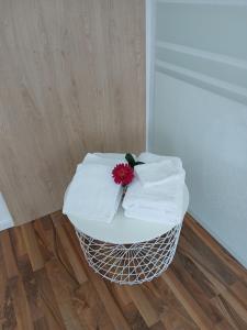 a white table with towels and a red flower on it at Ferien-Appartement Schröer in Nordwalde +5 photos