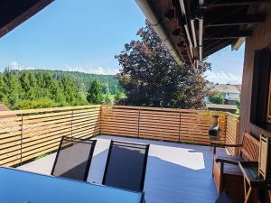 a balcony with two chairs and a wooden fence at Ferienwohnung Mei Ruh' in Burggen