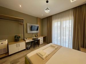 a bedroom with a bed and a desk and a television at Mont Blanc Hotel in Peshkopi