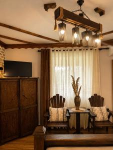 a living room with a table and chairs and a television at Forest House in Berat