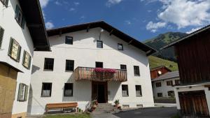 a white building with a balcony with flowers on it at Appartement Bergschaf in Holzgau