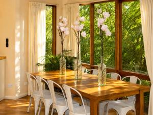 a dining room table with white chairs and vases with flowers at Risehill House in Kalorama