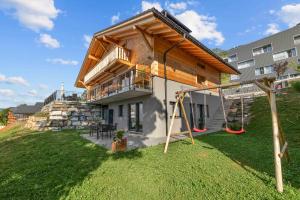 a house with a playground in the yard at Le Petit Lu in Leysin