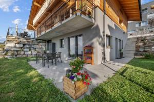 a patio of a house with a table and chairs at Le Petit Lu in Leysin