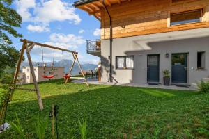 a swing in a yard next to a house at Le Petit Lu in Leysin