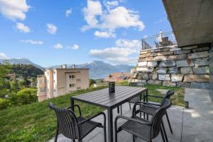 a table and chairs on a patio with a view at Le Petit Lu in Leysin