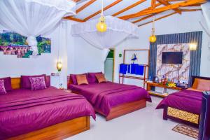 a large room with two beds and a tv at Ella Black Bridge Grand View Cottage Sri Lanka in Ella