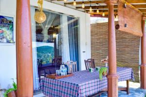 a table with a plaid table cloth on a porch at Ella Black Bridge Grand View Cottage Sri Lanka in Ella