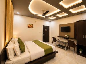 a bedroom with a bed and a desk and a television at Hotel Aaradhya Residency in Agra