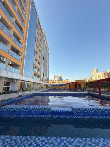 a large swimming pool in the middle of a building at 1BHK Suite with Balcony and Pool View in Noida