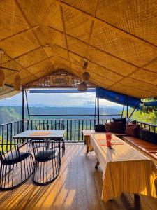 a restaurant with tables and chairs and a view of the ocean at Thrill Playgrounds & Tipi Cafe in Libona