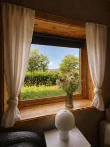 a window with a vase of flowers on a table at Linken Studio for 2 in Narvik