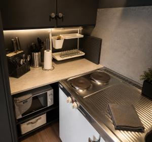 a small kitchen with a stove and a microwave at Linken Studio for 2 in Narvik