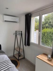 a bedroom with a room with a bed and a window at Dépendance climatisée au sud de Toulouse in Lacroix-Falgarde