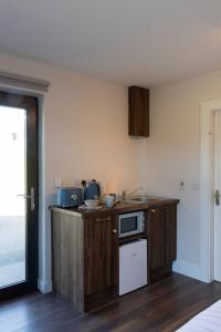 a kitchen with a counter with a microwave and a refrigerator at Dingle Lispole Garden Suite 10 B in Lispole +17 photos