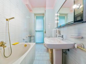 a white bathroom with a sink and a bath tub at La Dolce vista, Lecco apartment with lake view in Malgrate +35 photos