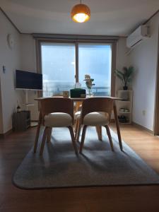 a dining room with a table and two chairs at Aju Good House 아주굿하우스 in Geoje