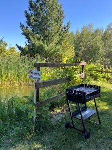 a picnic table with wine bottles on it next to a pond at Pensjonat i domki Kresy in Pogorzelce