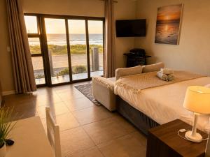 a bedroom with a bed and a view of the ocean at White Sands Self-catering units in Wilderness