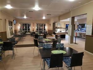 a restaurant with tables and chairs and a kitchen at Motoristen in Vara