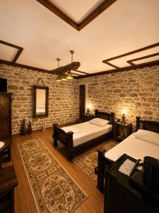 a bedroom with two beds and a brick wall at Forest House in Berat