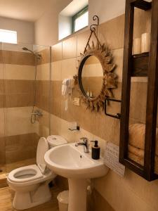 a bathroom with a sink and a toilet and a mirror at Forest House in Berat +73 photos