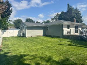 a house with a yard with a garage at Bright & Comfortable Home in the Heart of It All in Central Islip
