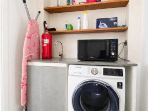 a kitchen with a washing machine and a microwave at Smart Suite at Villa Anna - Bike Friendly in Buonconvento