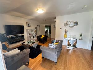 a living room with couches and a flat screen tv at Bright & Comfortable Home in the Heart of It All in Central Islip