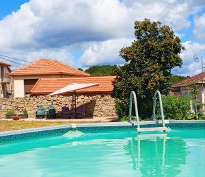 a swimming pool in front of a house at As Casiñas da Mina in Fechas