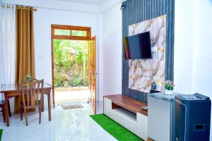a living room with a television and a dining room table at Ella Black Bridge Grand View Cottage Sri Lanka in Ella